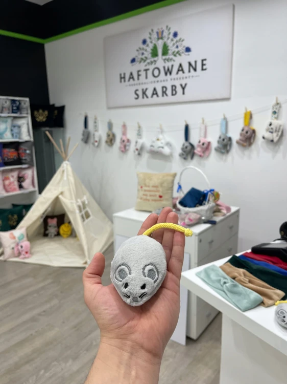 Szara pluszowa myszka trzymana w dłoni w pracowni Haftowane Skarby