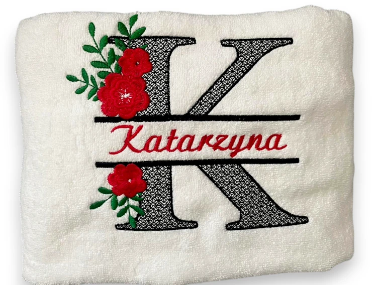 Biały ręcznik z haftowanym monogramem K, imieniem Katarzyna i czerwonymi kwiatami