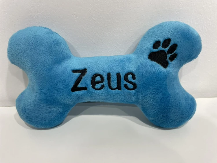Niebieska pluszowa kość z haftowanym imieniem Zeus i łapką